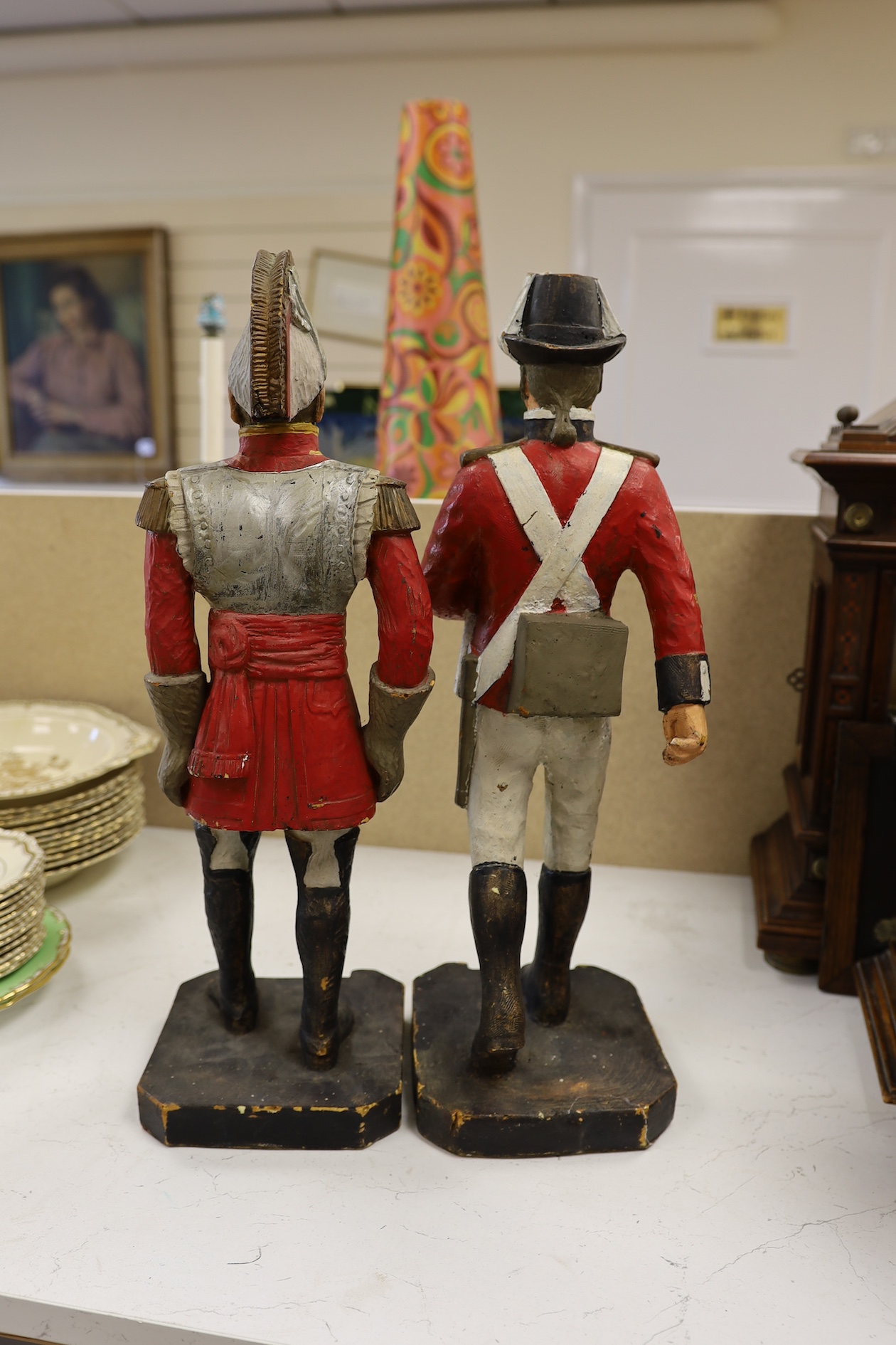 A pair of painted figures of soldiers in military dress, 49cm high. Condition - fair